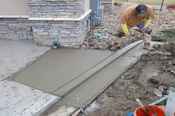 Crew member forming a concrete drain pan at a stone building in Colorado Springs