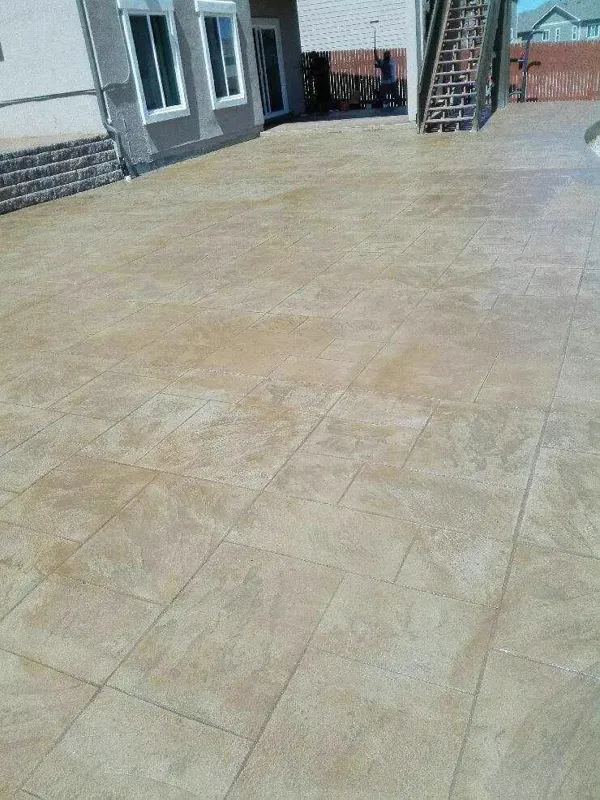 Large tan stamped concrete patio behind a home in Colorado Springs