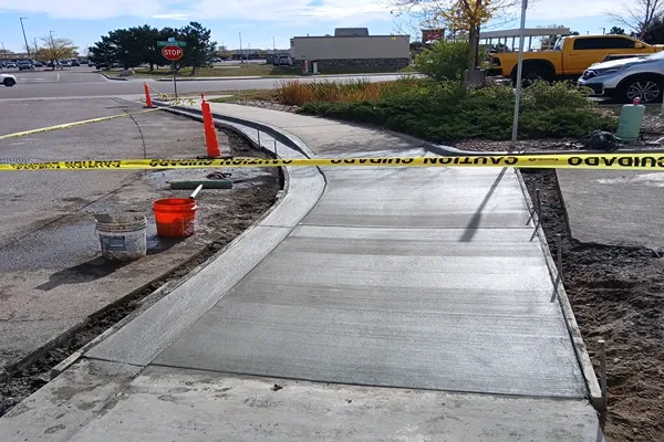 New curved concrete sidewalk with caution tape in Colorado Springs