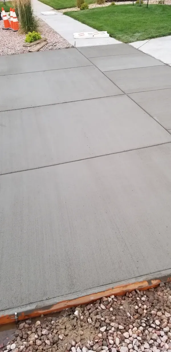 Stamped flagstone concrete walkway curving through gravel in Colorado Springs
