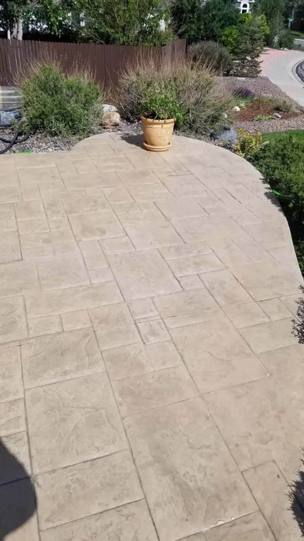 Tan stamped ashlar concrete patio with a curved edge in Colorado Springs