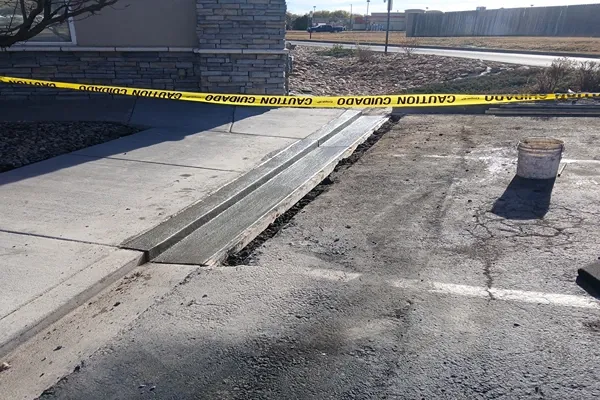 New concrete curb and gutter section beside a commercial parking lot in Colorado Springs