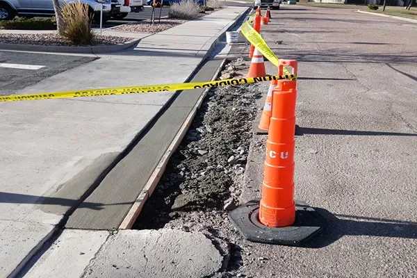 Freshly poured concrete curb and gutter next to a sidewalk in Colorado Springs